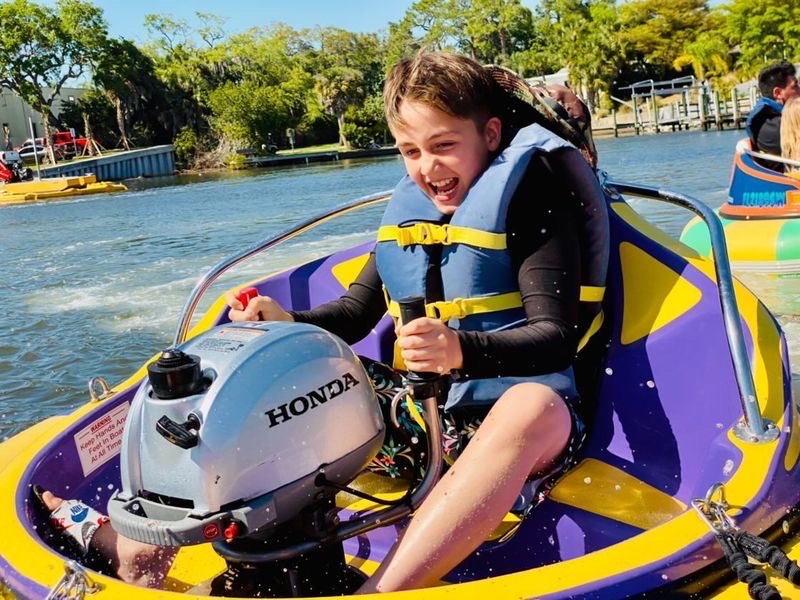 a young child riding on the back of a boat